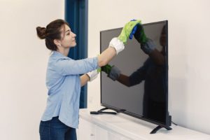 A woman cleaning TV screen